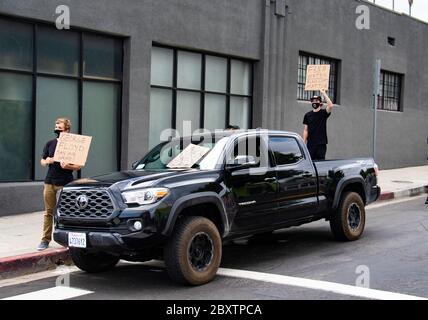 Two young white men carry protest signs during a George Floyd demonstration in Los Angeles, CA Stock Photo