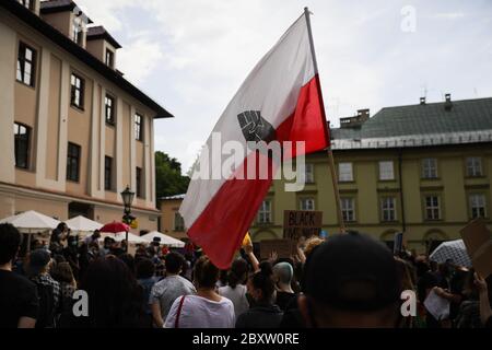 Cracow, Lesser Poland, Poland. 7th June, 2020. A Polish flag with a symbol of a black fist is seen during the Black Lives Matter protest.Hundreds of young people took part in 'Black Lives Matter' protest in Cracow, the biggest city in southern Poland. They paid tribute to George Floyd and expressed their disapproval of police brutality and racism. Credit: Filip Radwanski/SOPA Images/ZUMA Wire/Alamy Live News Stock Photo