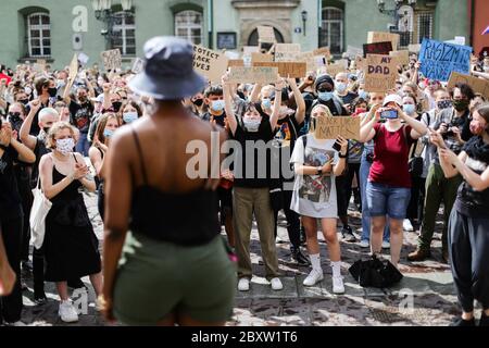 Cracow, Lesser Poland, Poland. 7th June, 2020. Protesters wearing facemasks and holding up protest placards during the Black Lives Matter protest. Hundreds of young people took part in 'Black Lives Matter' protest in Cracow, the biggest city in southern Poland. They paid tribute to George Floyd and expressed their disapproval of police brutality and racism. Credit: Filip Radwanski/SOPA Images/ZUMA Wire/Alamy Live News Stock Photo
