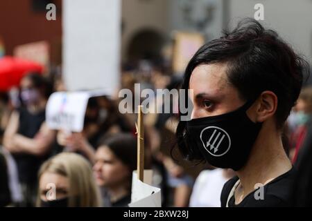 Cracow, Lesser Poland, Poland. 7th June, 2020. A young woman member of an anarchist group is seen wearing a facemask during the Black Lives Matter protest.Hundreds of young people took part in 'Black Lives Matter' protest in Cracow, the biggest city in southern Poland. They paid tribute to George Floyd and expressed their disapproval of police brutality and racism. Credit: Filip Radwanski/SOPA Images/ZUMA Wire/Alamy Live News Stock Photo