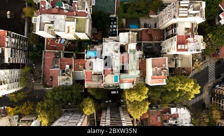 Aerial view of rooftops in different colors, height, surroundings, settings surrounded by autumn trees Stock Photo