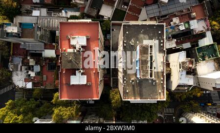 Aerial view of two tall apartment buildings next to each other really close surrounded by smaller buildings with different rooftop settings Stock Photo