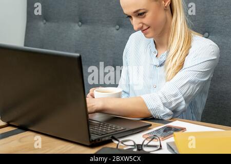 Young woman is using laptop during online learning at home office. Stock Photo