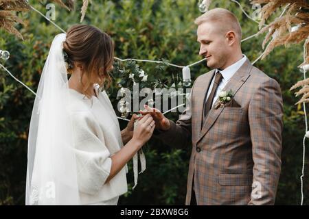 Bride putting the wedding ring on groom's finger. Bride and groom. Wedding ceremony.  Stock Photo