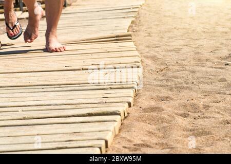 Feets on wooden path to the sandy beach Stock Photo