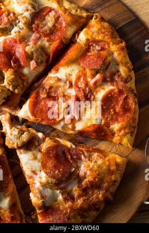 Savory Homemade Meat Lovers Pizza with Pepperoni and Bacon Stock Photo