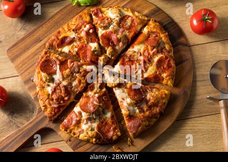 Savory Homemade Meat Lovers Pizza with Pepperoni and Bacon Stock Photo