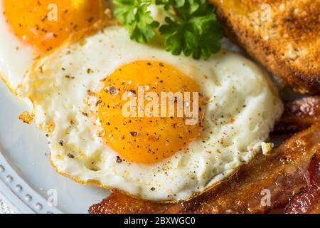 Homemade Sunnyside Eggs Breakfast with Toast and Bacon Stock Photo