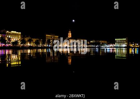 Split's Old Town buildings reflected in Split Harbour at night, Croatia Stock Photo