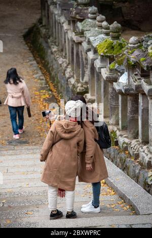 Visitors to the Kasuga Taisha shrine in Nara, Japan, taking a selfie on one of exterior shrine's staircases. Stock Photo