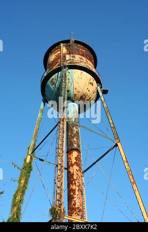 A Old rusty watertower against blue sky Stock Photo - Alamy