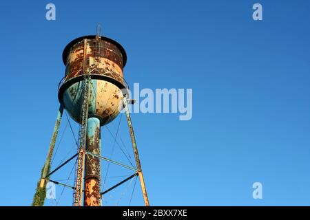 A Old rusty watertower against blue sky Stock Photo - Alamy