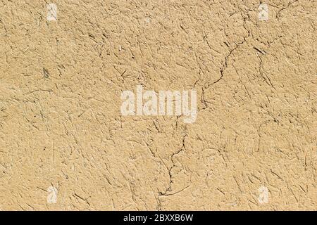 Adobe - clay and straw material weathered wall of rural old country house close-up as clay background Stock Photo