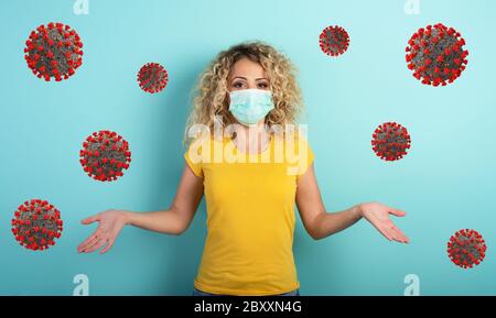 Blonde girl has doubt about covid19 corona virus. Cyan background Stock Photo
