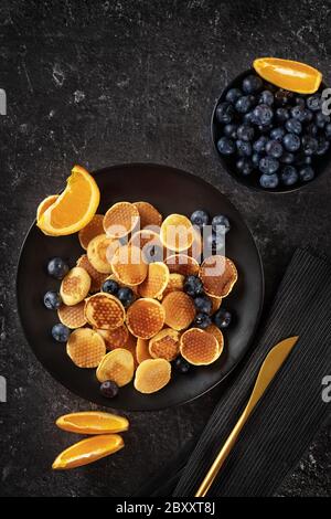 Top view over trendy mini pancakes on black background Stock Photo