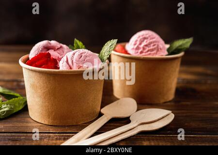 Close up of strawberry ice cream in eco craft paper cups Stock Photo