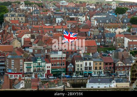 The British flag Union Jack flies over the town of Whitby, Scarborough, England Stock Photo