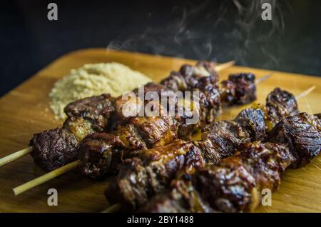 Juicy meat barbecue skewer (Churrasquinho, espetinho) in close up. Stock Photo