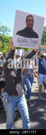 George Floyd Black Lives Matter Protest - Woman Holding George Floyd Sign walking vertical long royalty free stock photograph - Ridgefield Park Bergen Stock Photo