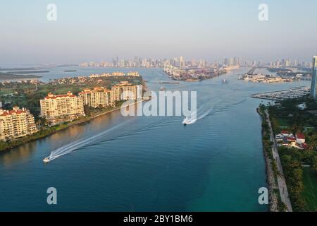 Aerial view of Fisher Island, South Pointe and Government Cut with City of Miami skyline and Port Miami in background at sunrise. Stock Photo