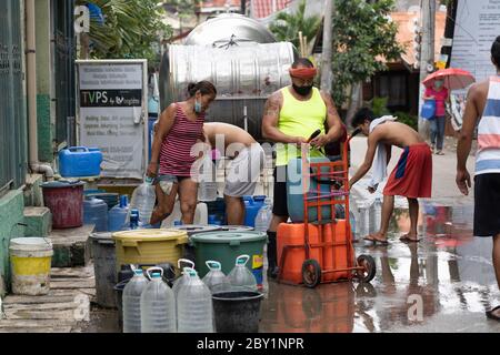 With Cebu City operating under quarantine conditions as of 09/06/2020,residents within a poor community collect free clean drinking water from a water tanker provide by local authorites. Stock Photo