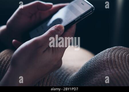 Closeup of hands holding the mobile phone for business and personal use. Selective focus. Copy space. Stock Photo