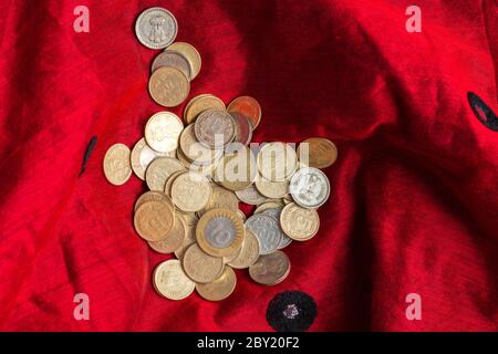 Indian five and ten rupee coins are kept in a red cloth Stock Photo