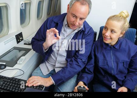 aero engineer and apprentice working in hangar Stock Photo