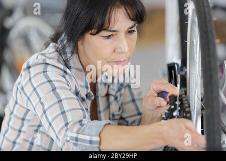 woman is examining bicycle wheel Stock Photo