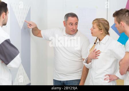 students listening to teacher in painting and decorating class Stock Photo