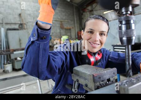 female engineer using drill in factory Stock Photo