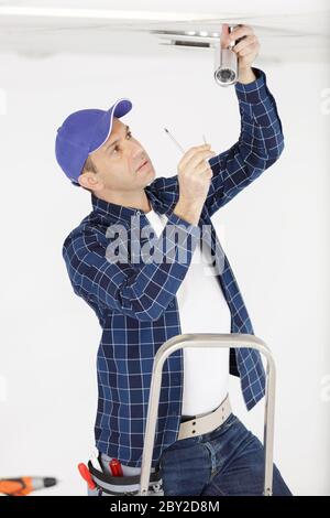 mature handyman installing cctv camera Stock Photo