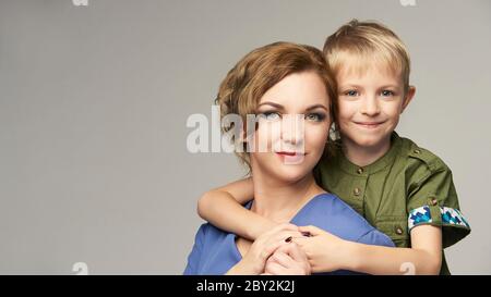 Pretty mature mom with cute baby boy. Piggyback portrait together. Mother parent Stock Photo