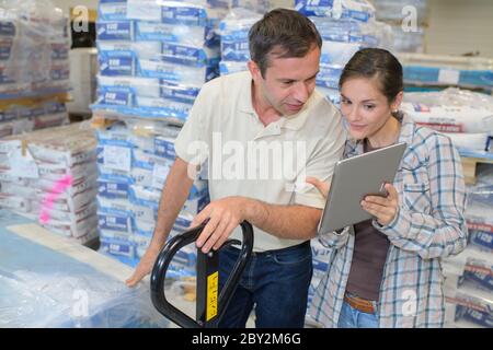 male engineer with female apprentice checking stock levels Stock Photo