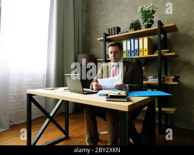 Businessman sitting at desk working with financial statements. The auditor checks the report. Stock Photo