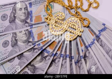 Gold Dollar Sign Necklace on a United States Dollars Banknotes. Stock Photo