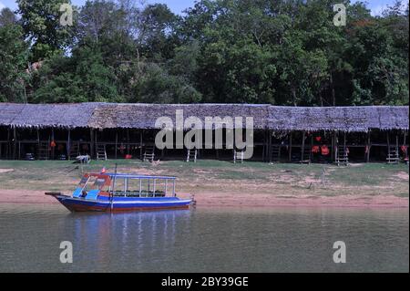 A tour boat sits idle on the West Baray Reservoir. Thatched roof huts / shacks normally busy w/ international tourists, now empty due to the virus. the local Cambodians have almost no business during the coronavirus pandemic. Angkor Archaeological Park, Siem Reap Province, Cambodia. May 30th, 2020. © Kraig Lieb Stock Photo