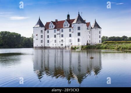 Historic castle with reflection in the lake in Glucksburg, Germany Stock Photo