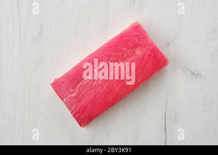 Raw frozen tuna fillet on wooden background Stock Photo