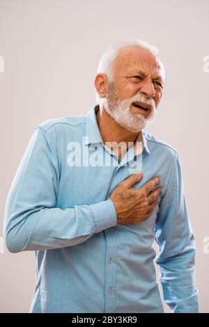 Portrait of senior man who is having pain in his chest. Stock Photo