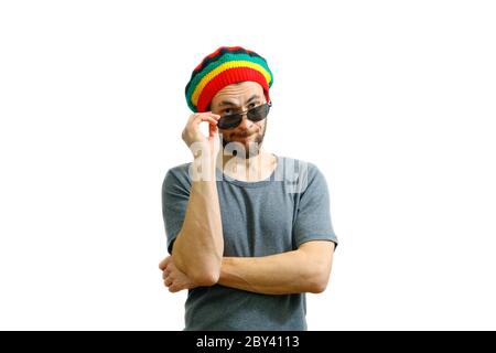 Young caucasian man in rasta hat and grey t-shirt holding sunglasses in hand Stock Photo