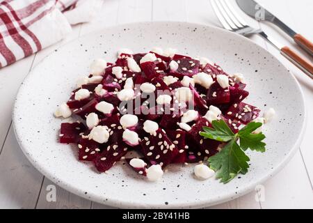 Salad of boiled beetroot and grain curd with sesame seeds on a plate Stock Photo