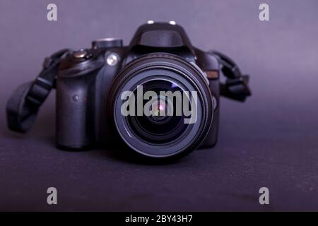 Professional modern DSLR camera low key image. Modern camera with a very wide aperture lens in front view. Stock Photo