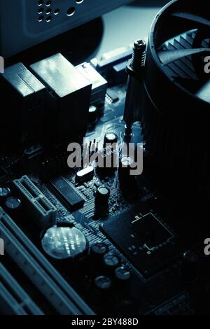Components on PC circuit board. Chip, fan, capacitor and connectors on the motherboard of a personal computer. Inside photo for background Stock Photo