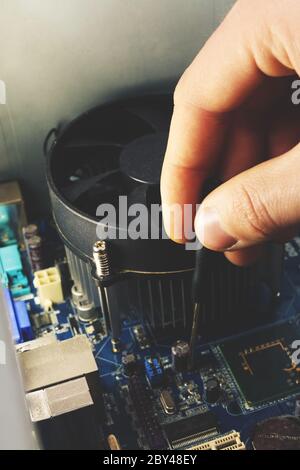 Close-up on the hands with screwdriver tool of the technician repairing a PC computer Stock Photo