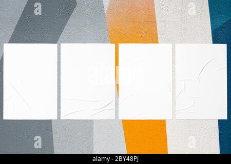 close up of colorful urban wall texture with wrinkled glued poster templates Stock Photo