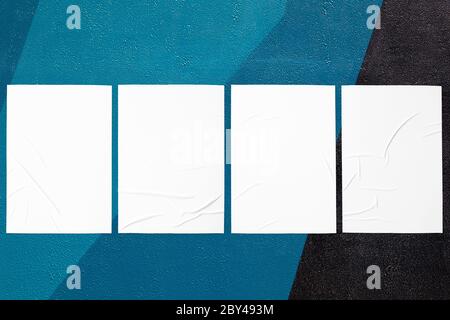 close up of colorful urban wall texture with wrinkled glued poster templates Stock Photo