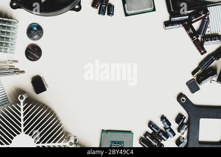 Top view of computer parts with CPU, fan cooler, battery, capacitors, radiator, chip on white table background with copy space in the center Stock Photo