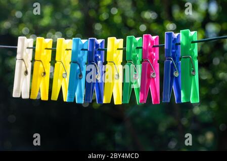 Group of multicolor clothespins hanging on a rope Stock Photo