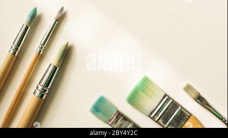 Dirty brushes for painting on the white textured paper Stock Photo
